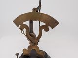 une vieille balance en laiton surmontée d'une horloge