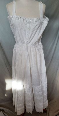 the dress is white and has a lace overlay on it