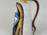 a ceramic pitcher with a painting of a woman on it