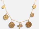 a close up of a gold necklace with a cross on it