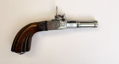 un vieux pistolet avec une poignée en bois sur une surface blanche