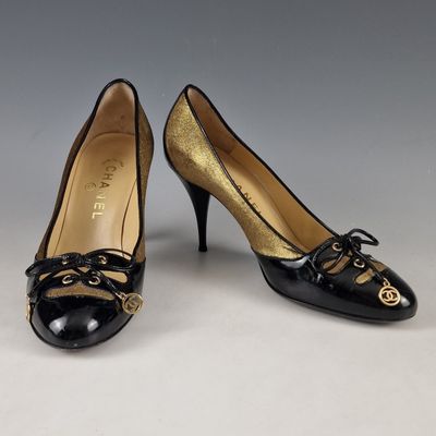a pair of black and gold shoes with a gold heel