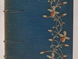 un vieux livre à la couverture bleue ornée de fleurs dorées
