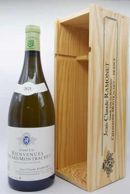 une bouteille de vin blanc dans un coffret en bois, à côté d'une bouteille de vin