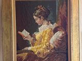 un tableau représentant une femme en train de lire un livre, accroché au mur