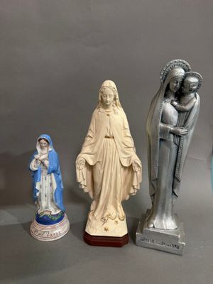 Plusieurs figurines représentant Jésus et Marie sont exposées sur une table