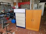 a cabinet in the middle of a room with a chair in it