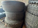 two tires are stacked on a pallet next to a pile of other tires