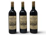trois bouteilles de vin rouge posées l'une à côté de l'autre sur une surface blanche