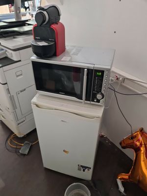 un micro-ondes posé sur un réfrigérateur dans une cuisine