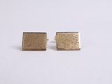 a pair of gold square stud earrings on a white background