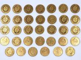 a close up of a bunch of gold coins on a white surface