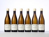 four bottles of wine are lined up on a table