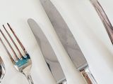 four forks, a knife, and a spoon on a table