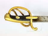a close up of a gold and black sword on a white surface