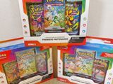 Trois paquets de cartes Pokémon sont posés sur une table