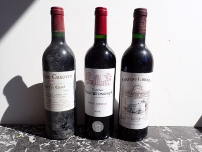 trois bouteilles de vin posées l'une à côté de l'autre sur une table