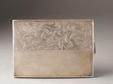 an antique silver cigarette case with a floral design on the front