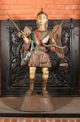 une statue représentant un homme tenant une épée et un oiseau