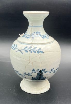 a white and blue vase with a bird on it