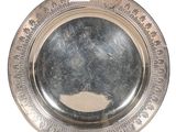 une assiette en argent sur laquelle est représenté un homme