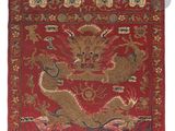 un tapis oriental rouge et doré orné d'un dragon