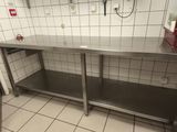 une table de travail en acier inoxydable dans une cuisine aux murs carrelés