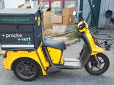 a yellow scooter with a box on the back of it