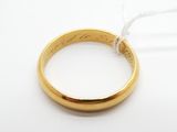 un gros plan d'une bague en or avec un fil, posée sur une surface blanche