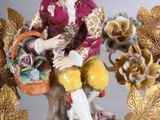 a figurine of a man holding a basket of flowers