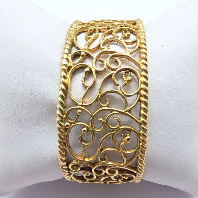 une photo en gros plan d'un bracelet en or posé sur une serviette