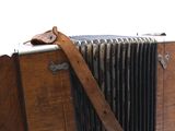 an old wooden camera with a leather strap on it