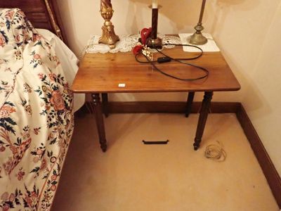 une petite table sur laquelle est posée une lampe, dans un coin de la pièce