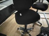 a black office chair sitting in front of a computer desk