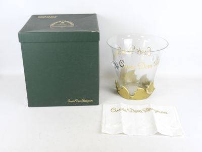 un verre orné d'une couronne dorée, à côté d'une boîte verte