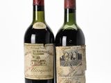 two bottles of wine sitting next to each other on a white surface