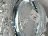 a glass vase with a label on it sitting on a table