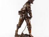 a bronze statue of a man with a dog on a leash