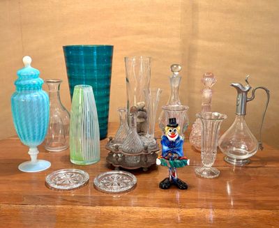 de nombreux vases en verre et autres objets en verre sur la table