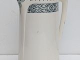 a white pitcher with a blue design on it