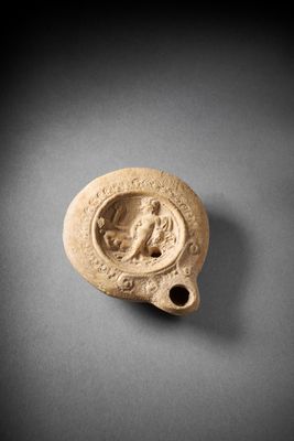 a small clay vase with a picture of a woman on it