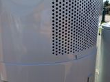a white air conditioner sitting on the side of the road