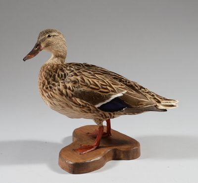 un canard posé sur un bloc de bois