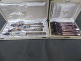 two sets of silverware in a case on a table