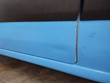 the side of a blue car with a black stripe on it