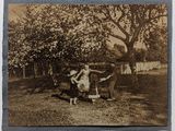 une vieille photo représentant une femme et un enfant dans la cour