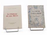 pair of books sitting on a metal stand on a white surface
