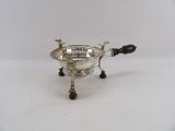 an antique silver plated sugar bowl with a black handle