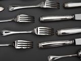 a lot of forks and spoons that are on a table