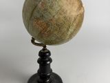 an old globe on a black stand with a white background